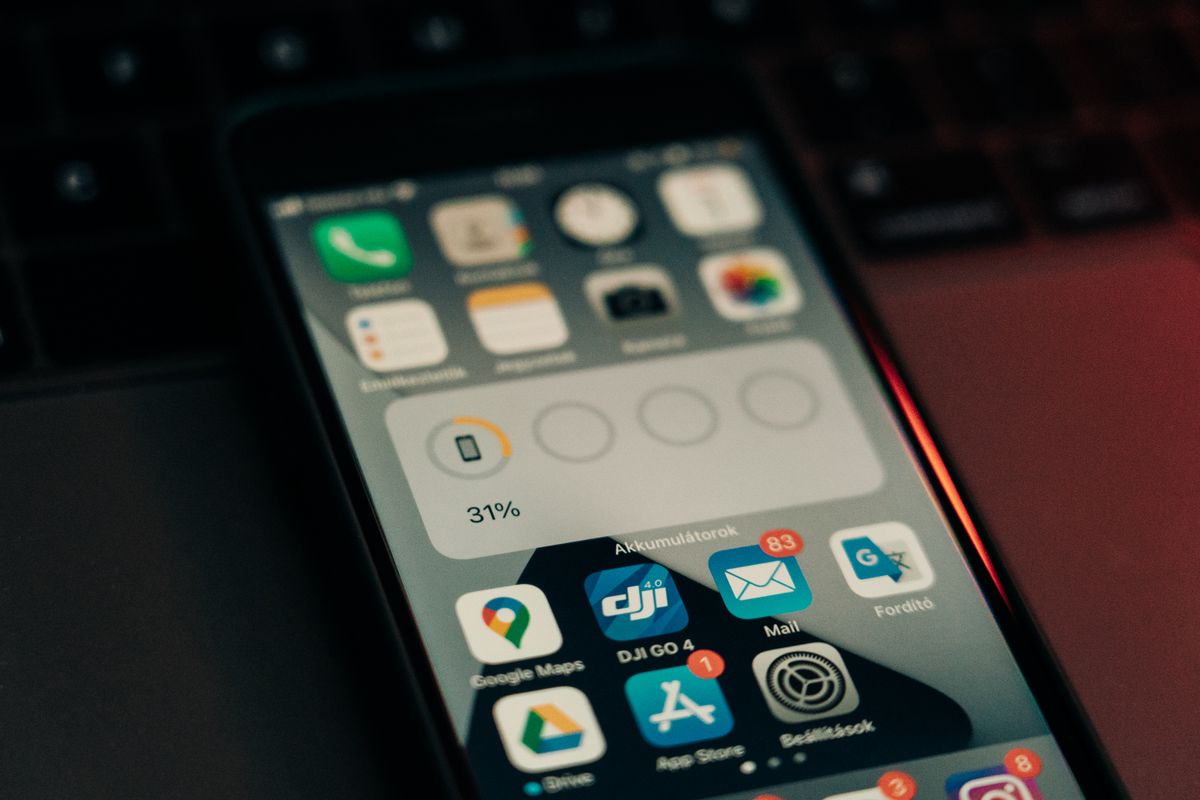 A smartphone lying on a keyboard, its battery widget showing a low 31 percent charge